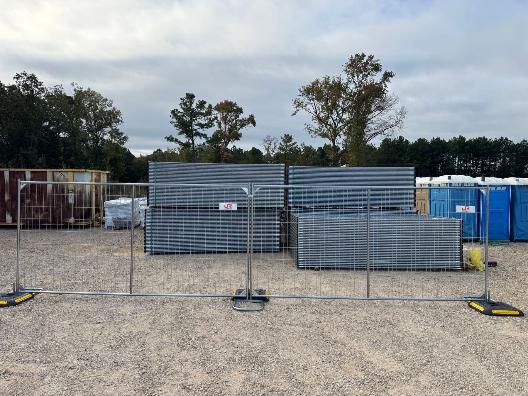 JOTS Rentals temporary fence panels standing on weighted bases in the yard