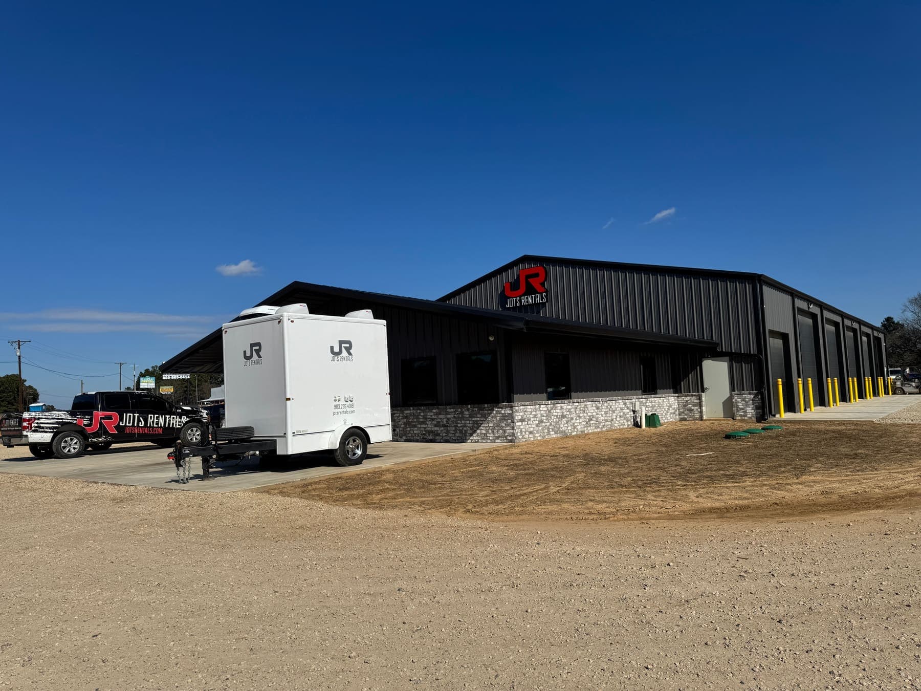 The JOTS Rentals Tyler yard on Highway 155 in Flint, with a restroom trailer and service truck parked outside the shop